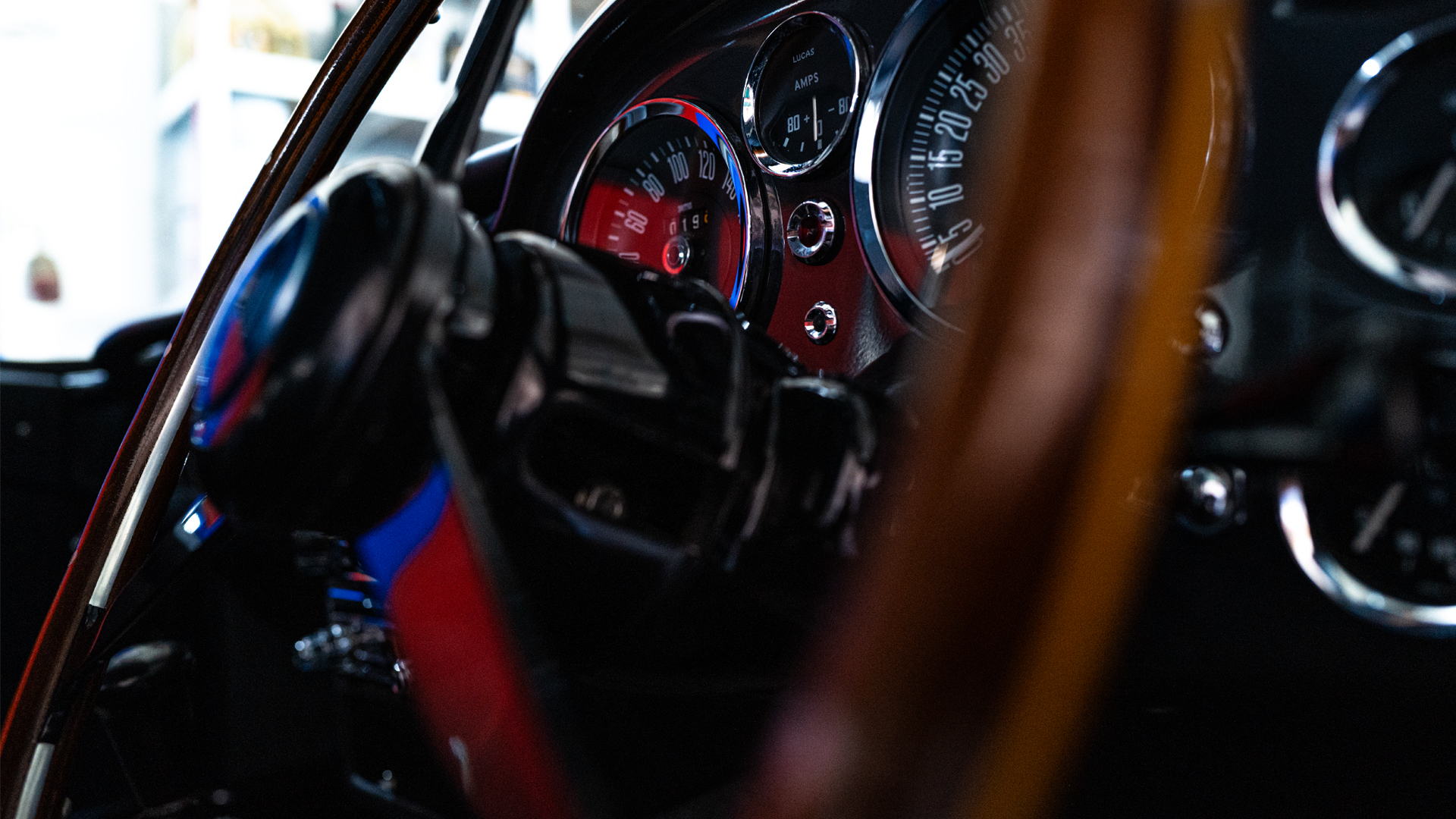 Cockpit eines Oldtimers mit Holzlenkrad und Rundinstrumenten